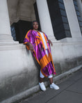 Load image into Gallery viewer, Womens Bird of Paradise Pink Purple Plus Size and Mid Size Silk Kimono styled with a white top and white jeans, creating a fresh ensemble.