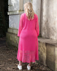 Load image into Gallery viewer, Women's Aphrodite Hot Pink Holiday Resort Dress with a hot pink undergarment shown from the side, paired with white sneakers