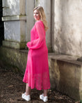Load image into Gallery viewer, Women's Aphrodite Hot Pink Holiday Resort Dress with a hot pink undergarment shown from the side, paired with white sneakers