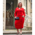 Load image into Gallery viewer, Women's Red Plus Size Ruched Bodycon Midi Dress styled with quartz jewelry by Veronique Designs, black clutch, and gold Kurt Geiger sandals.