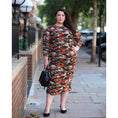 Load image into Gallery viewer, Women's Plus Size Orange Green Grey Camouflage Bodycon Midi Dress styled with a black handbag and black heels for a modern, stylish look.