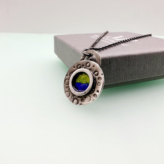 Round handstamped silver pendant with blue and green enamel